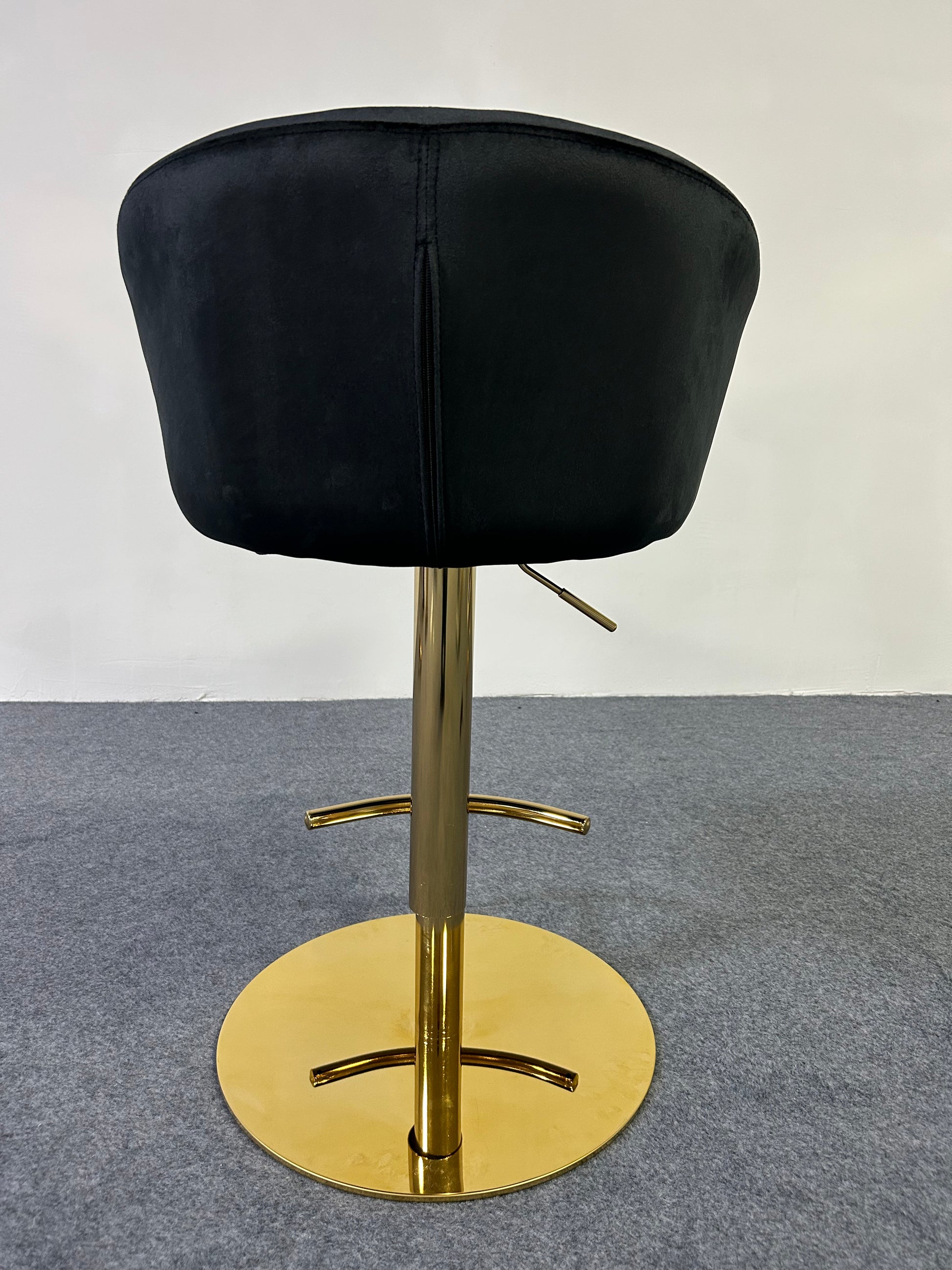 Back view of a sleek Modern Golden Barstool with a black velvet seat and shiny gold base.