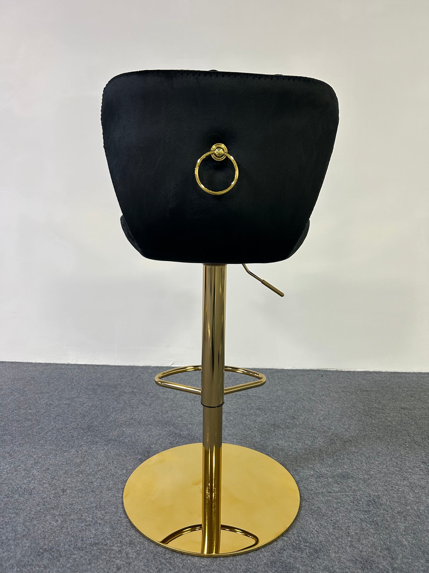 Luxury Golden Barstool with a sleek black cushion and gold base, featuring a decorative ring on the back.