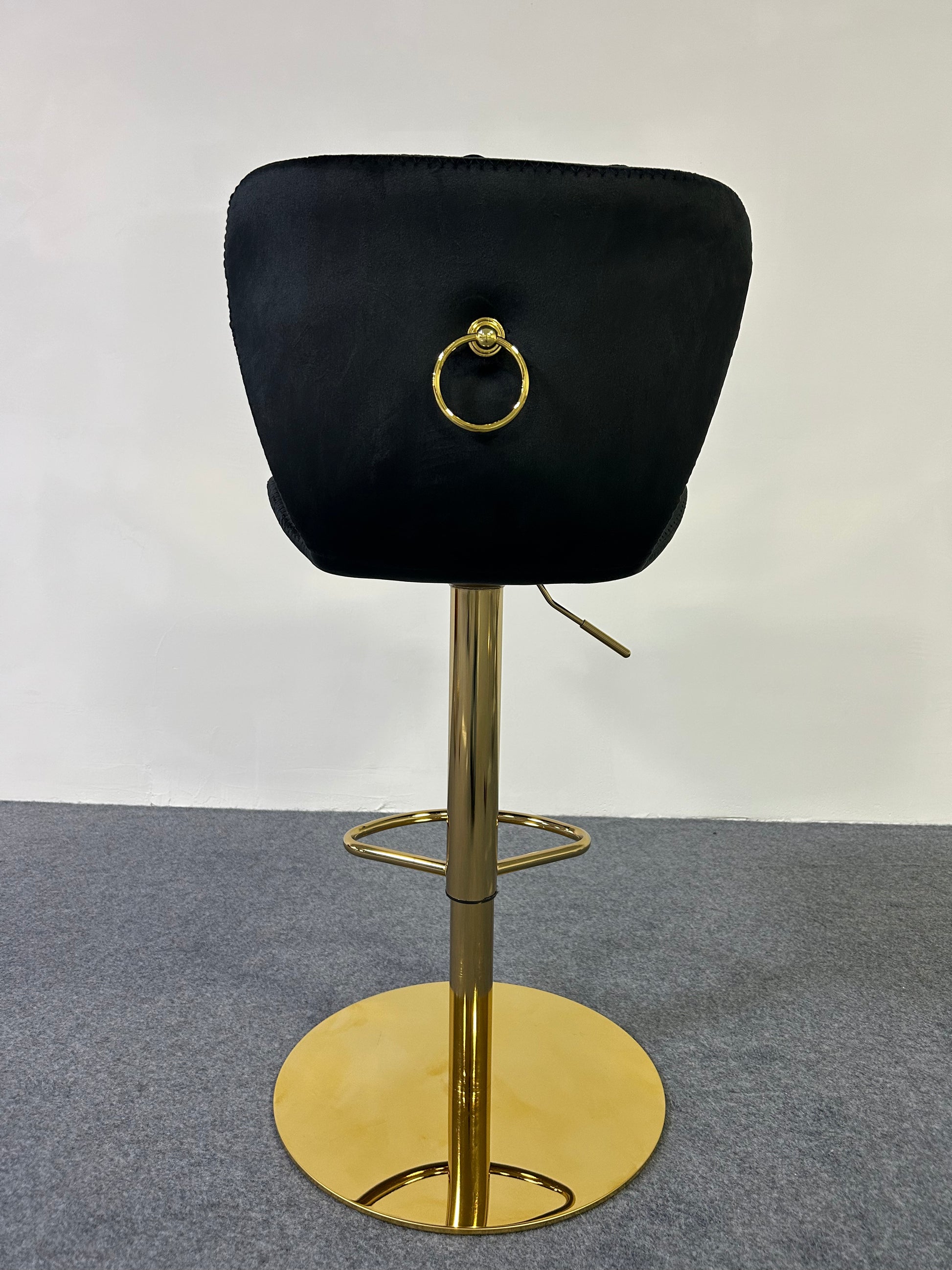 Luxury Golden Barstool with a sleek black cushion and gold base, featuring a decorative ring on the back.