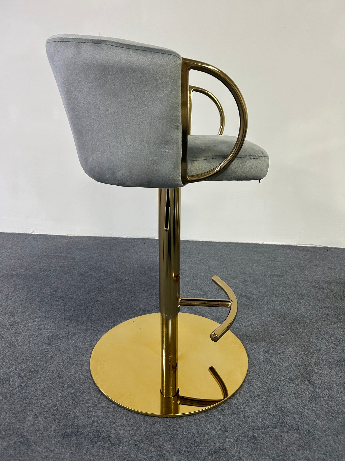Modern Golden Barstool featuring a sleek design with a gold base and plush gray seat.