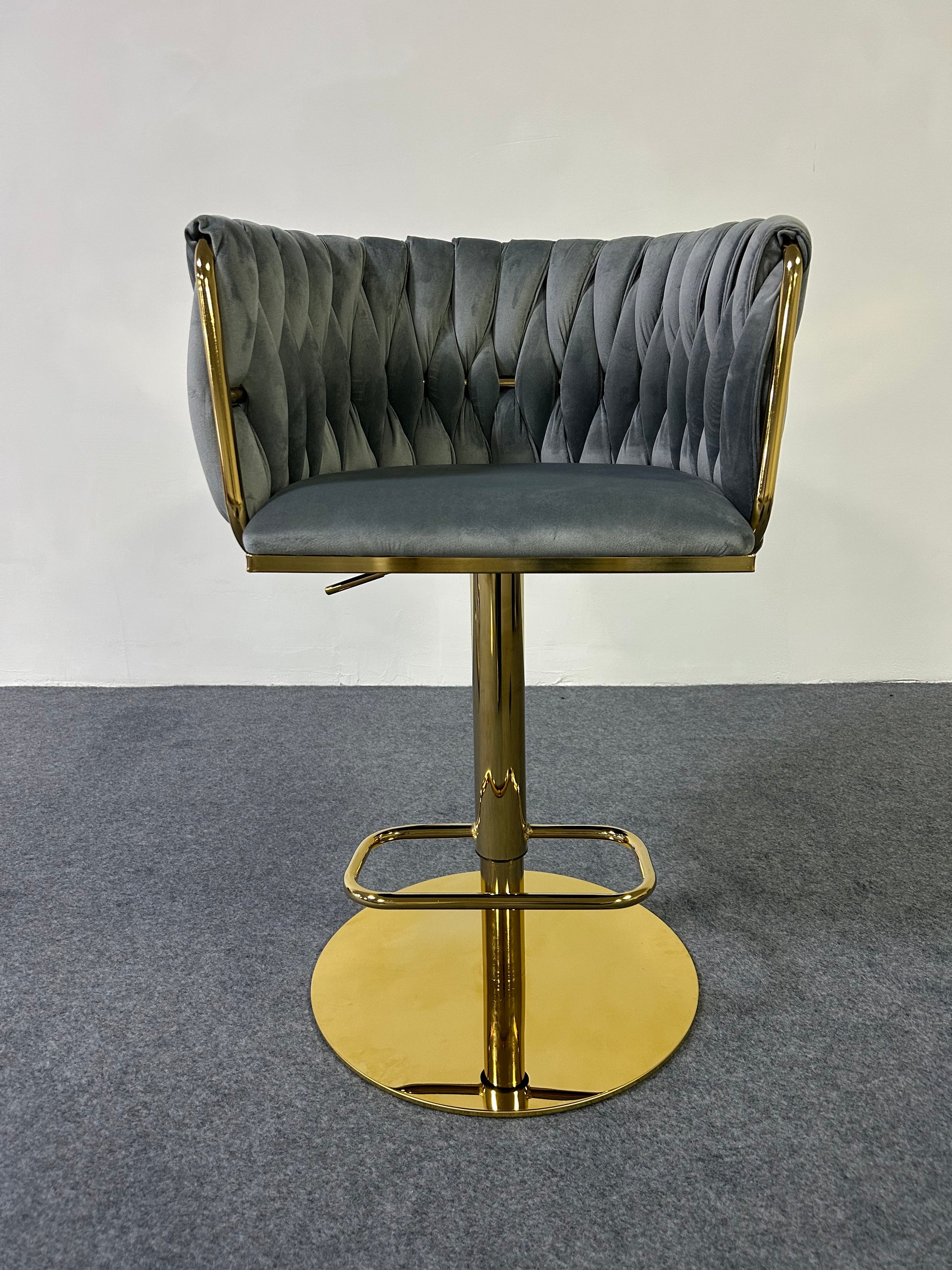 Golden Barstool with tufted gray upholstery and gold base on a gray carpet background.